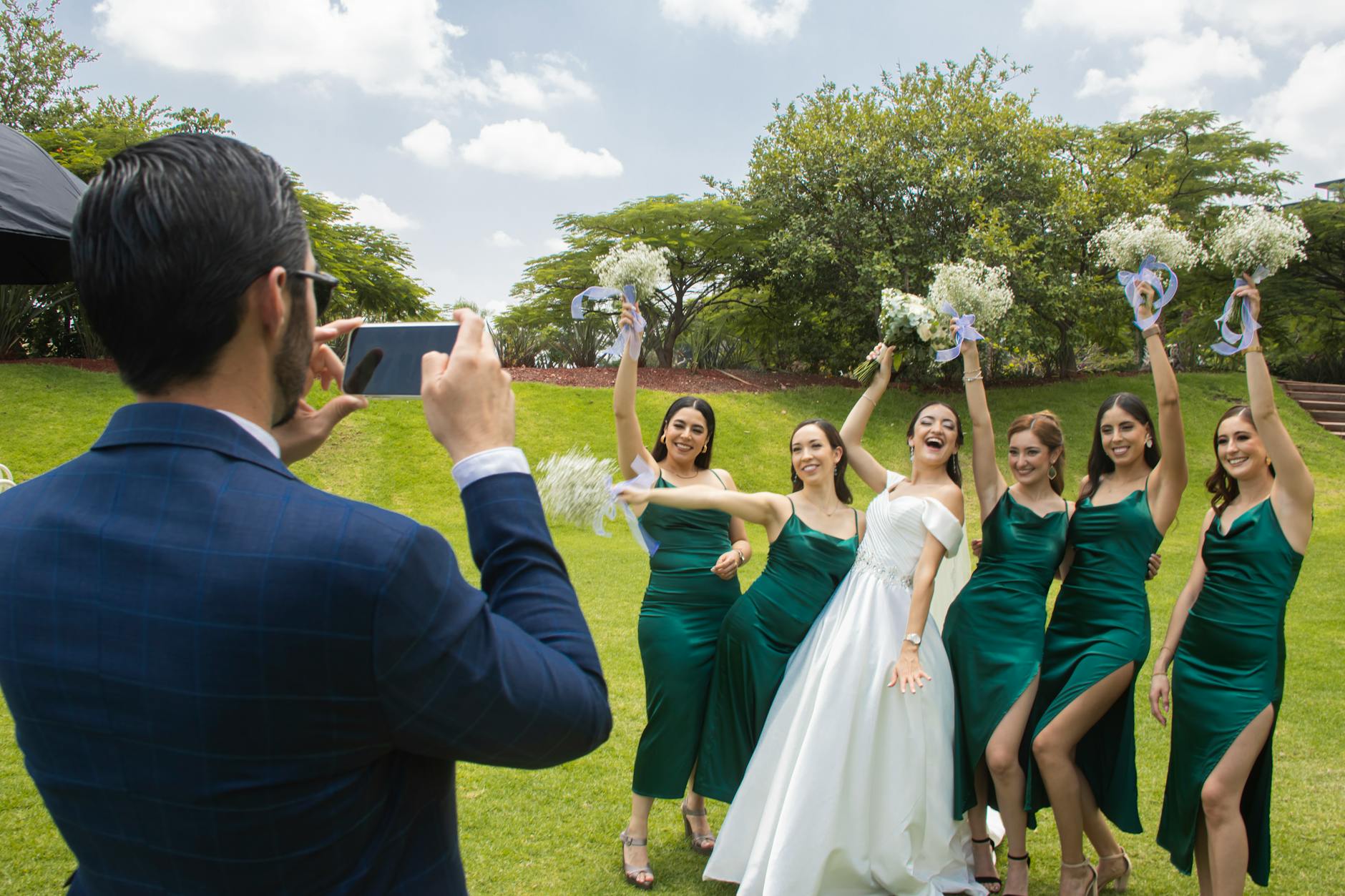 A happy bride and bridesmaids posing outdoors for a wedding photo in León de los Aldama.