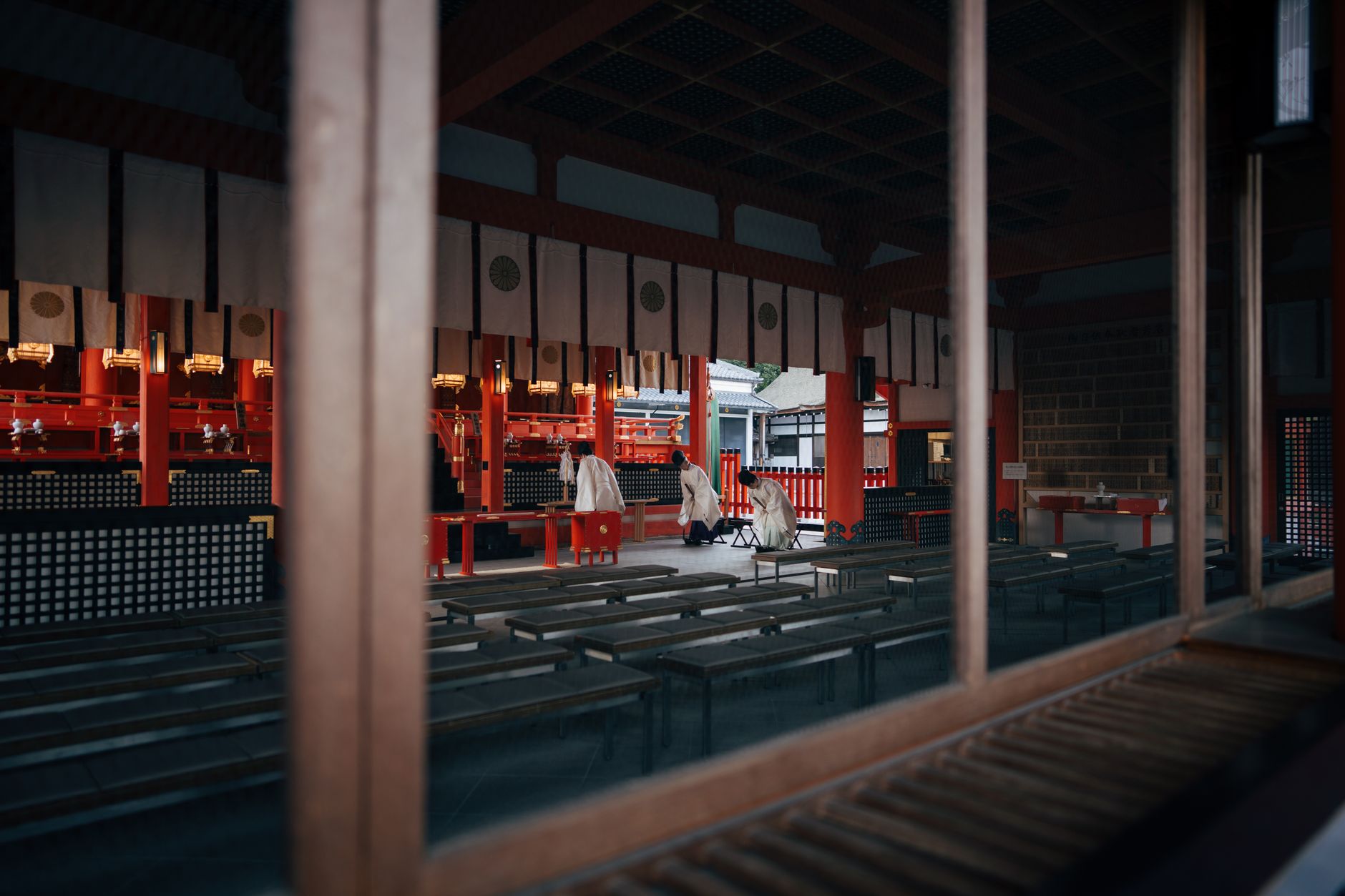 A serene moment captured inside a Kyoto shrine showing priests preparing for a traditional ceremony.