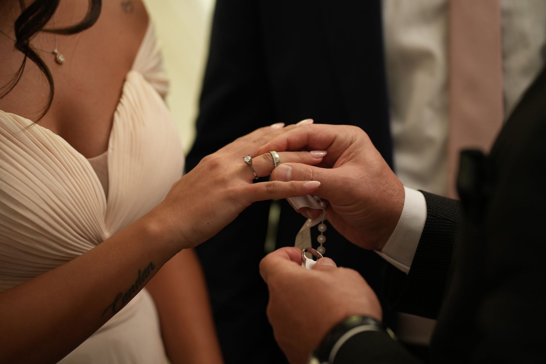 A close-up of a couple exchanging wedding rings during their ceremony, capturing a moment of love and commitment.