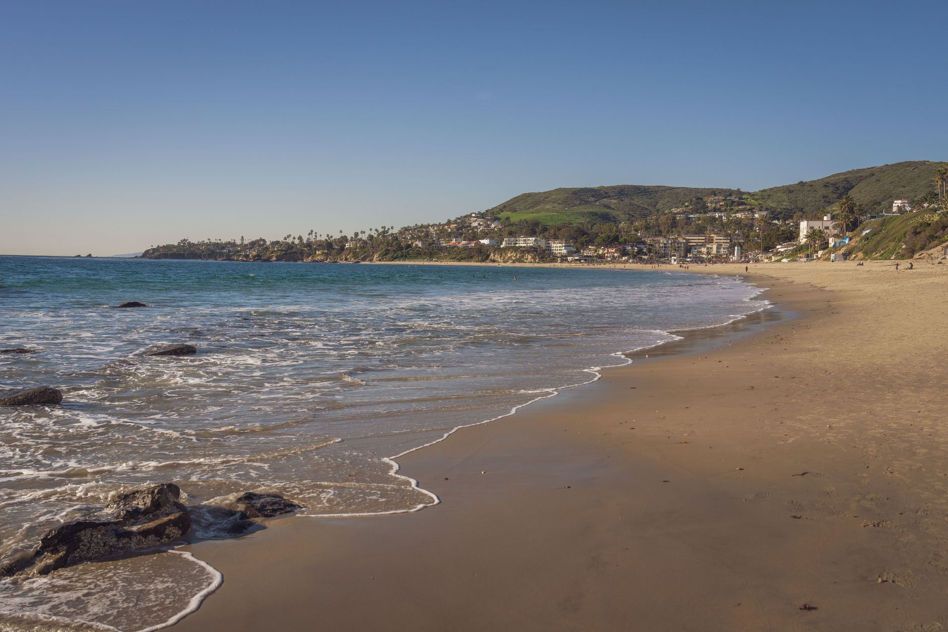 A picturesque view of Laguna Beach with clear skies and gentle waves.