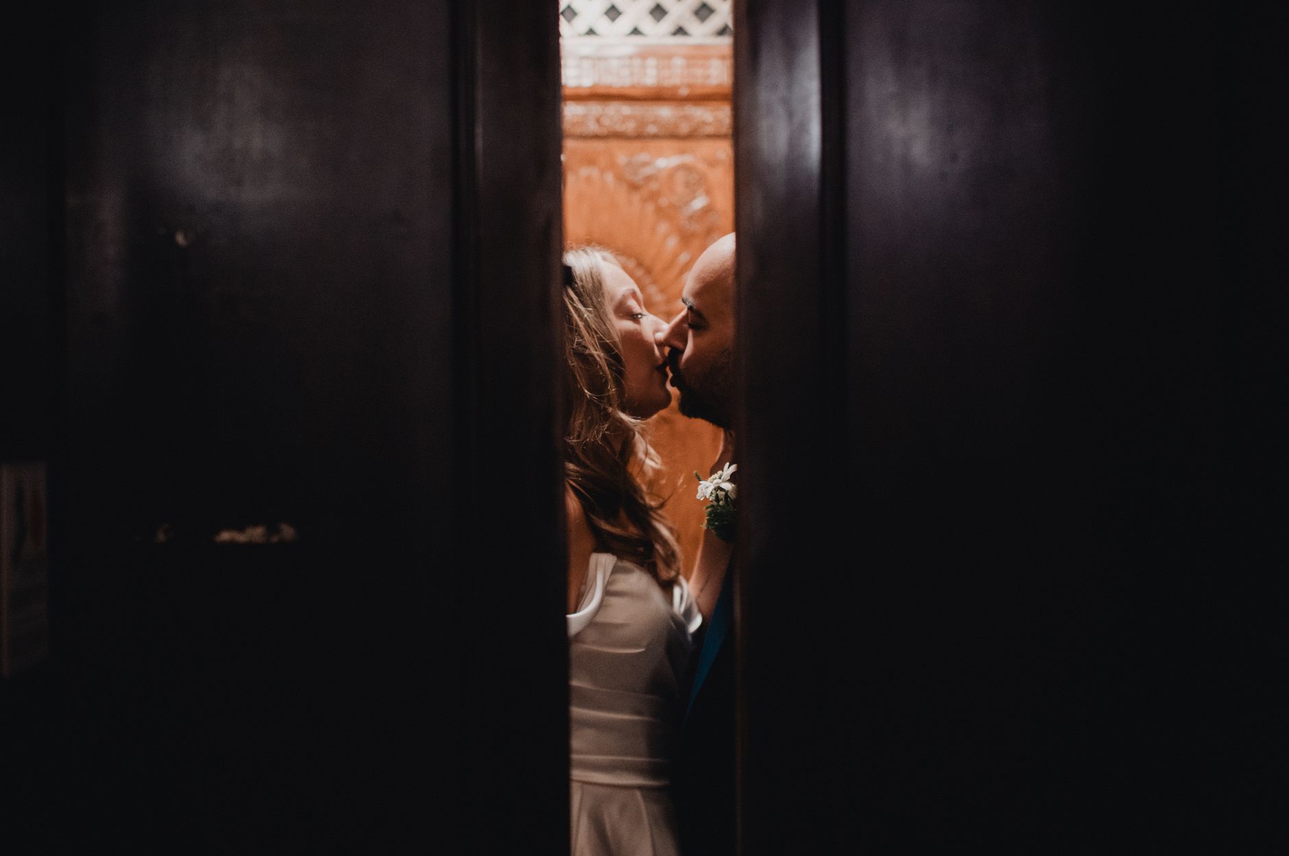 Intimate moment of a couple kissing in an elevator, captured in Los Angeles.