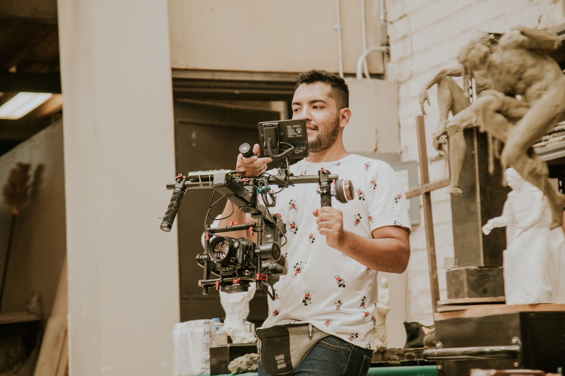 Videographer working with a professional stabilizing rig indoors, capturing behind-the-scenes moments.
