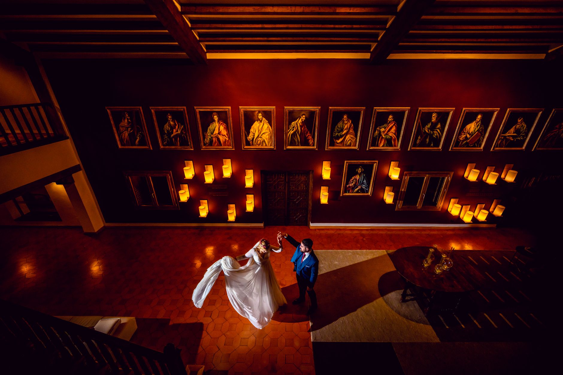 Couple dancing indoors, surrounded by art, showcasing elegance and romance in Toledo, Spain.