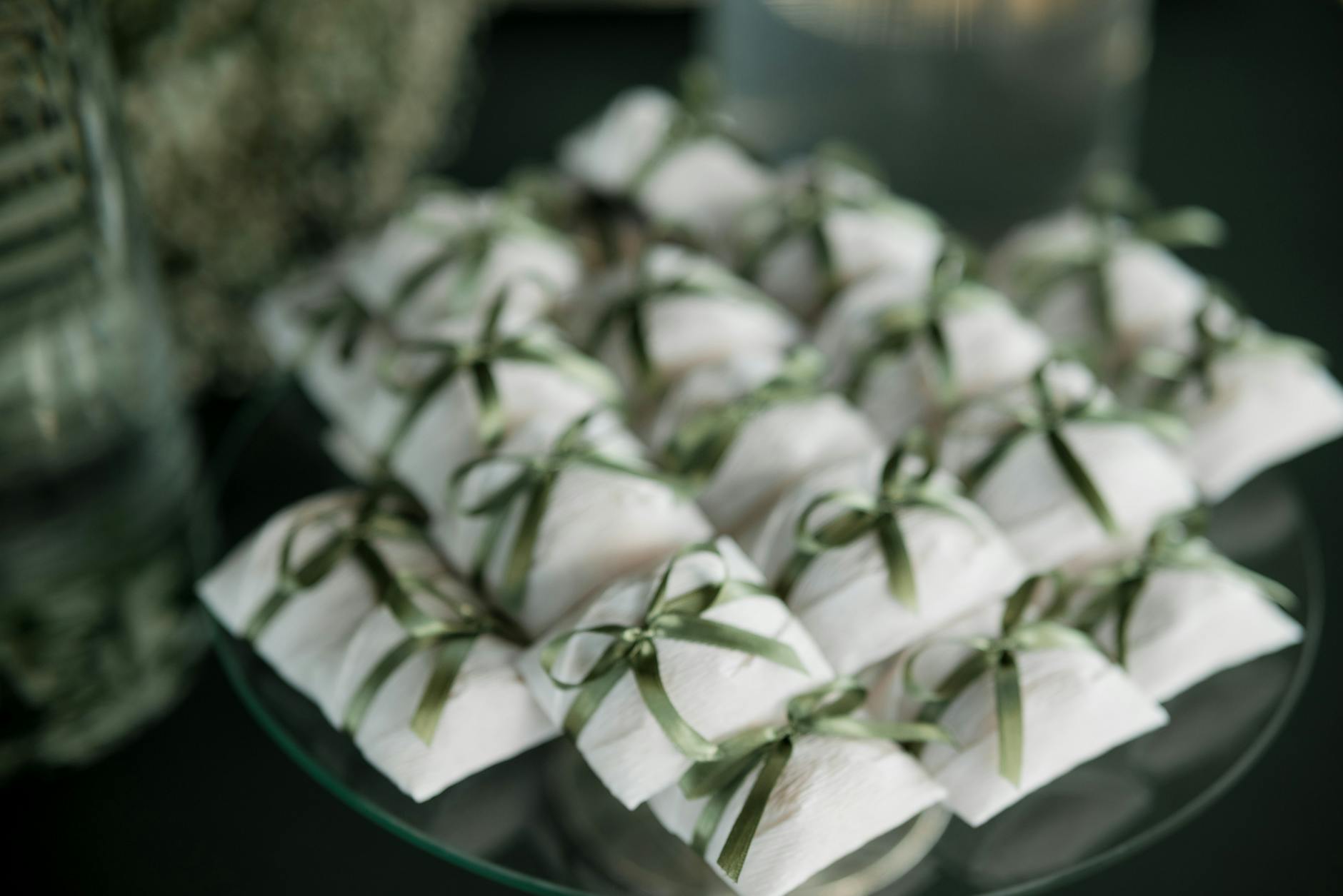 A collection of white gift boxes tied with green ribbons, perfect for weddings or special events.