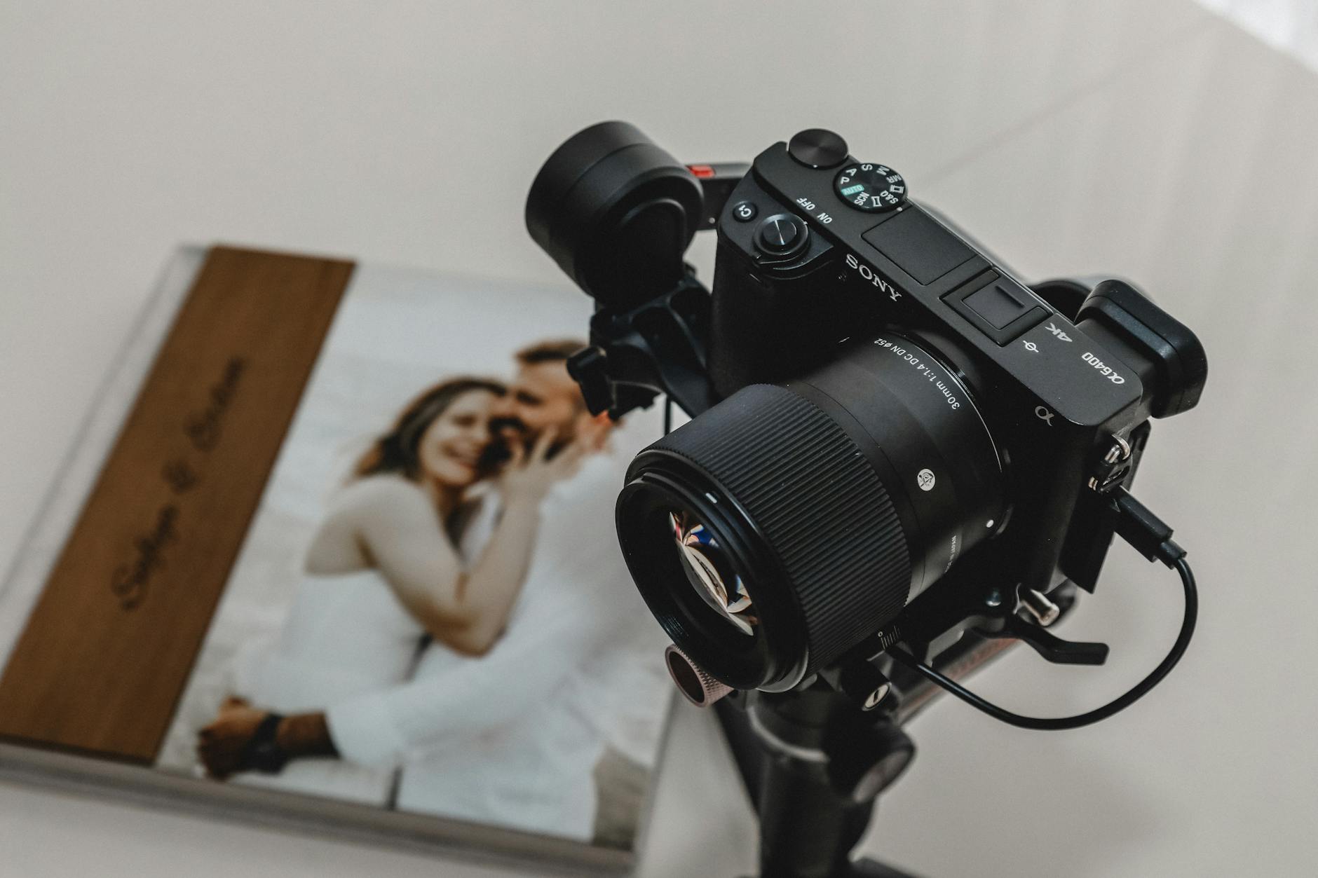 High-quality camera on tripod next to wedding photo album, ideal for photography shoots.