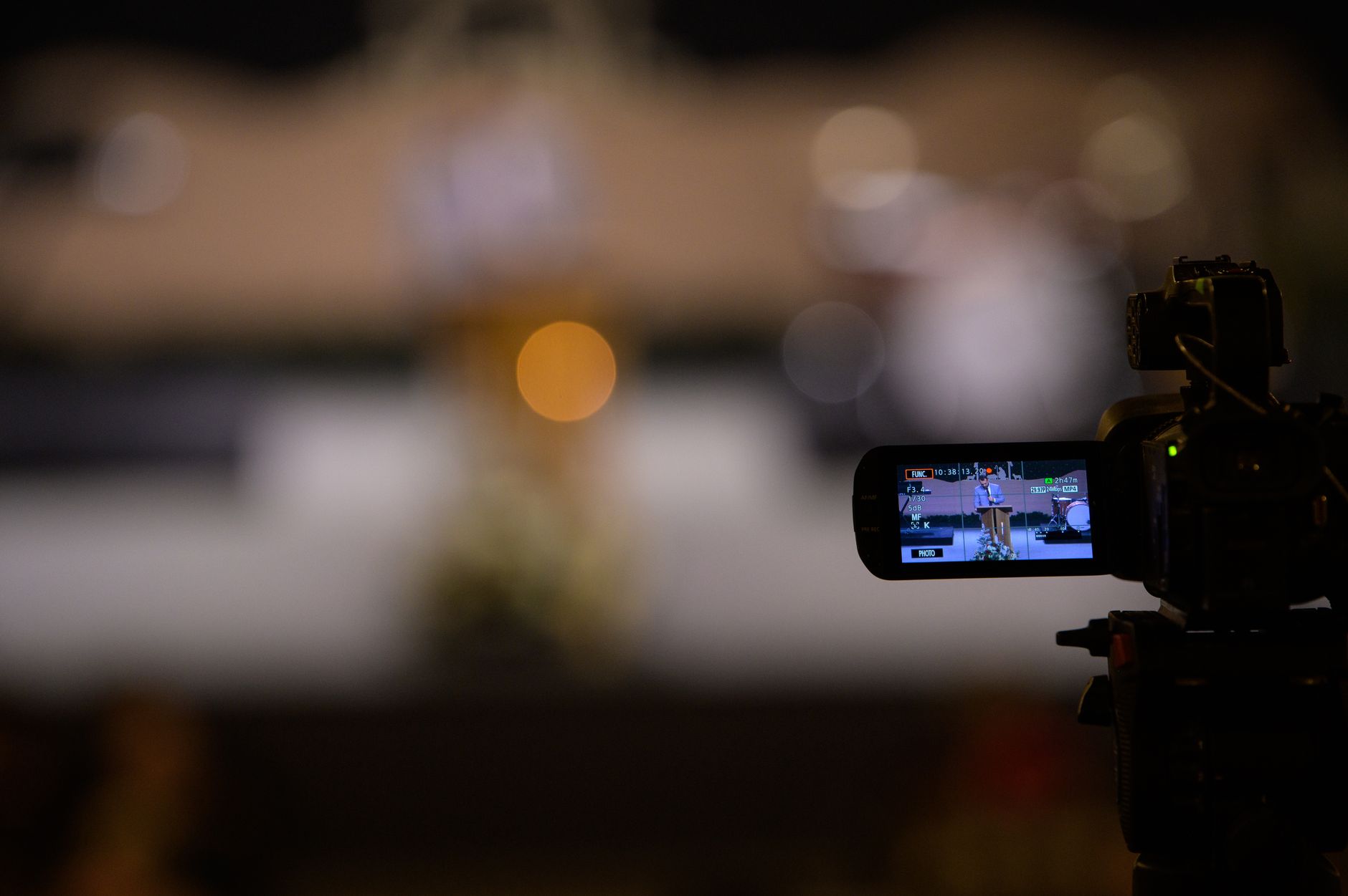 Video camera capturing an event with blurred bokeh background night scene.