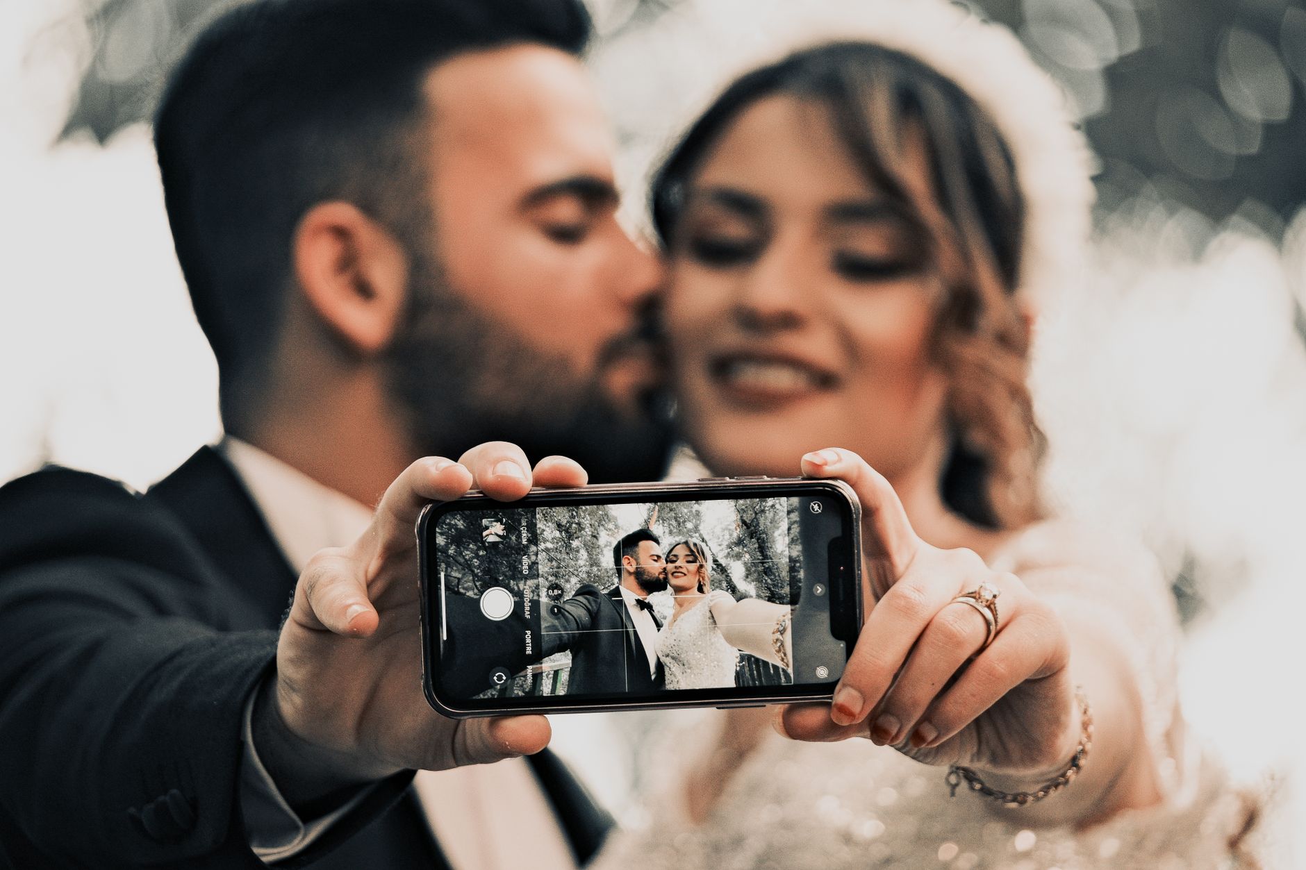 A couple takes a selfie on their wedding day, capturing a moment of love and happiness.