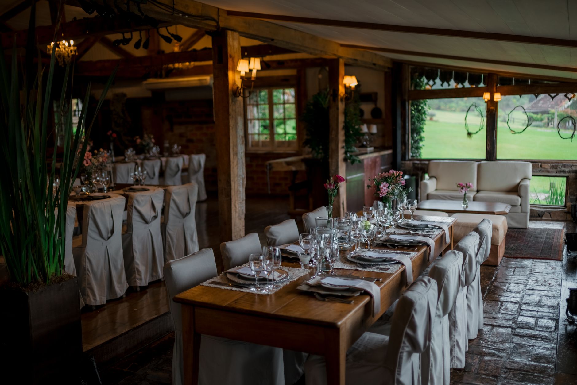 Beautifully decorated wedding reception with elegant table setting in a rustic indoor venue.