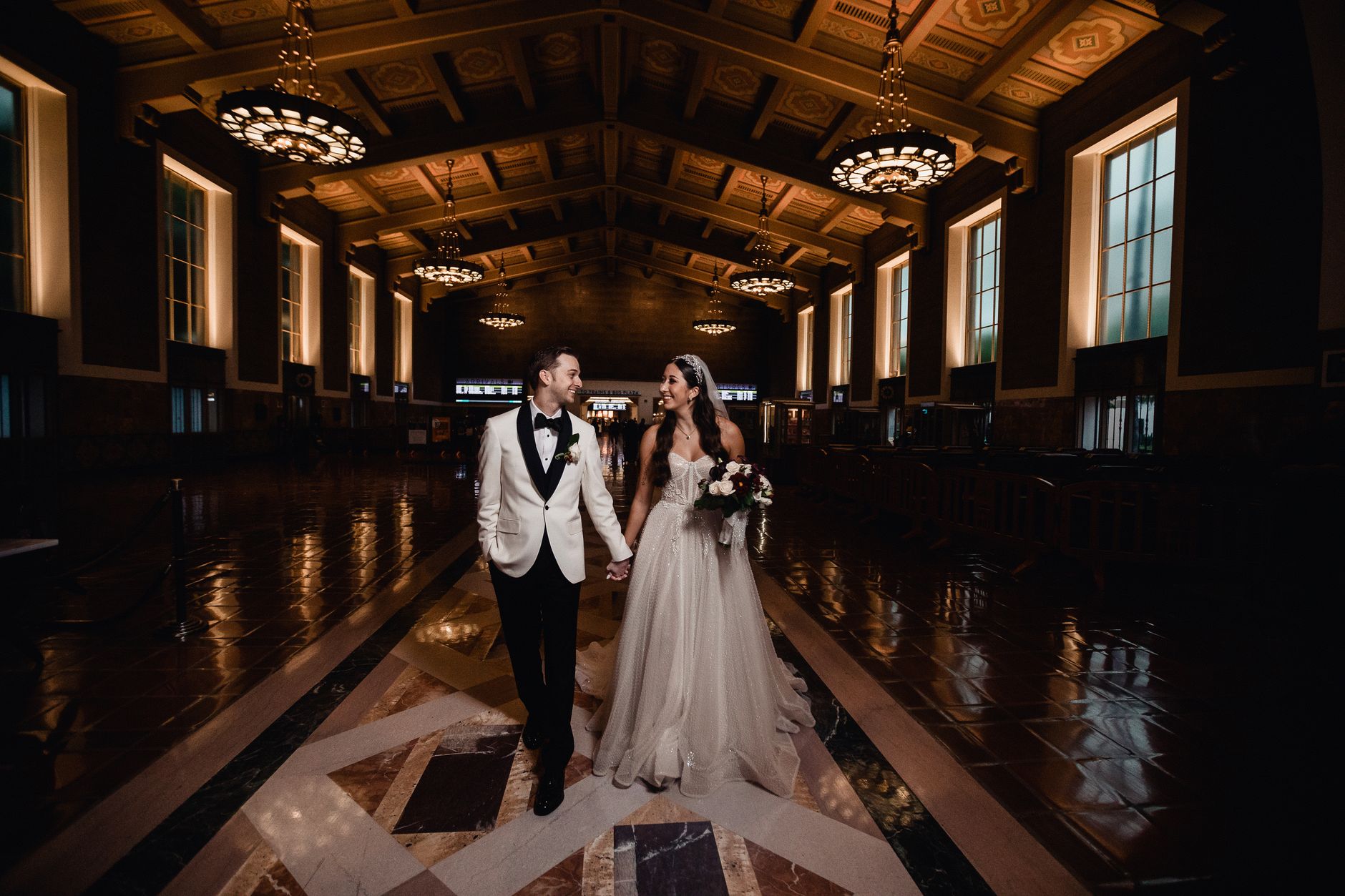 A couple shares a romantic moment at Los Angeles Union Station on their wedding day.