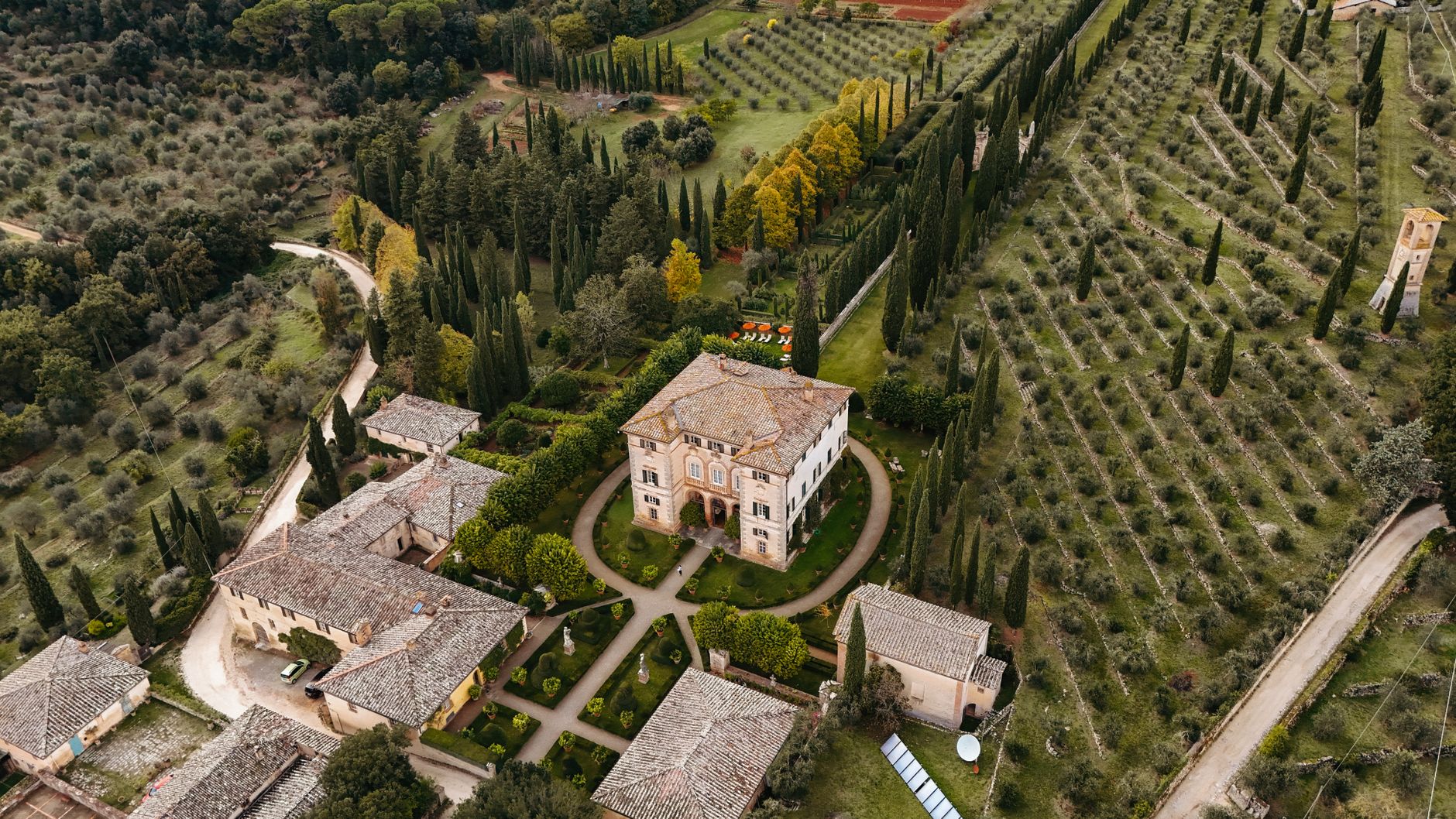 Stunning aerial shot of a Tuscan villa surrounded by olive groves and cypress trees, capturing the essence of Italy.