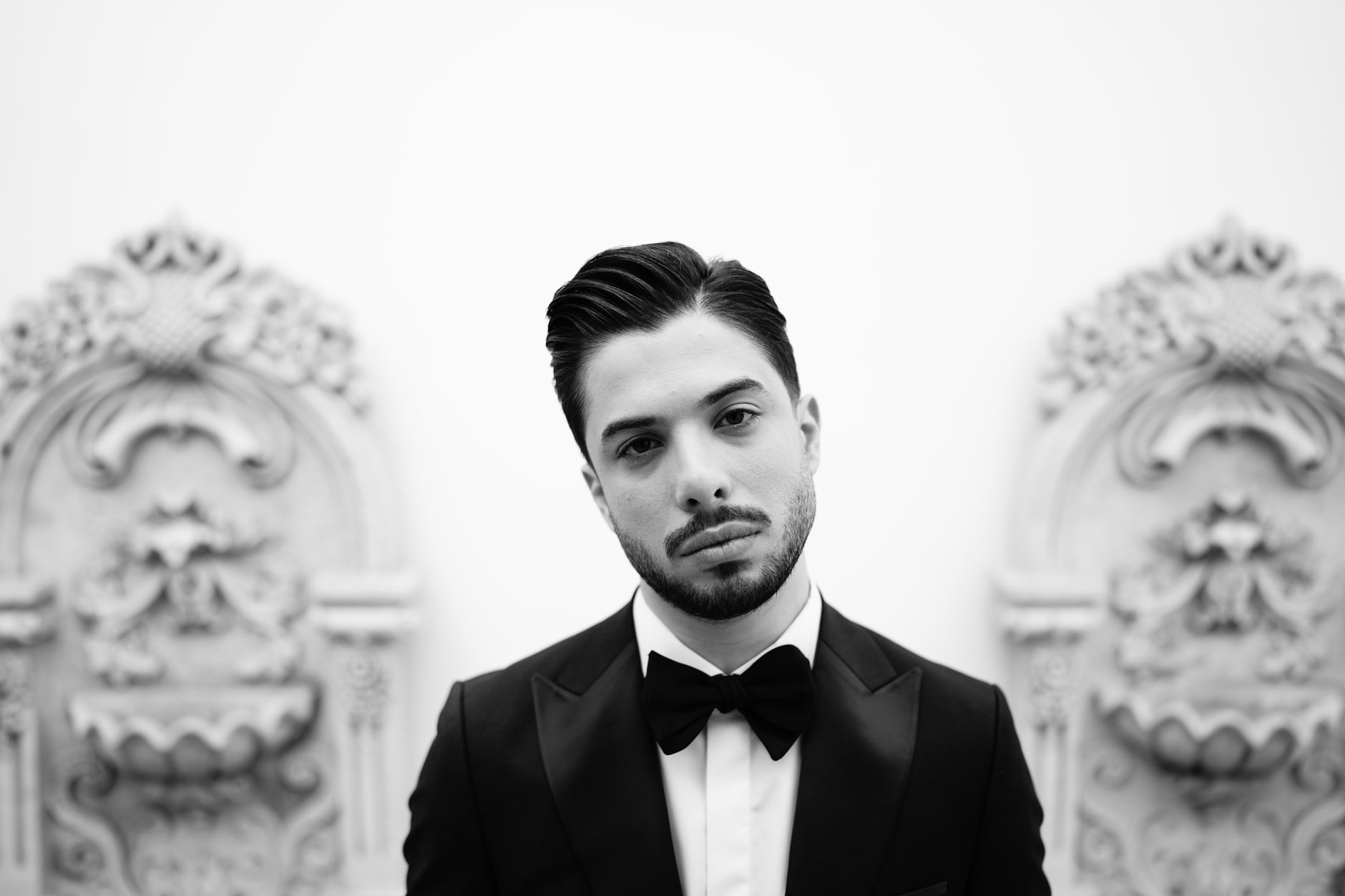 Elegant black and white portrait of a young man in a tuxedo, exuding timeless sophistication.
