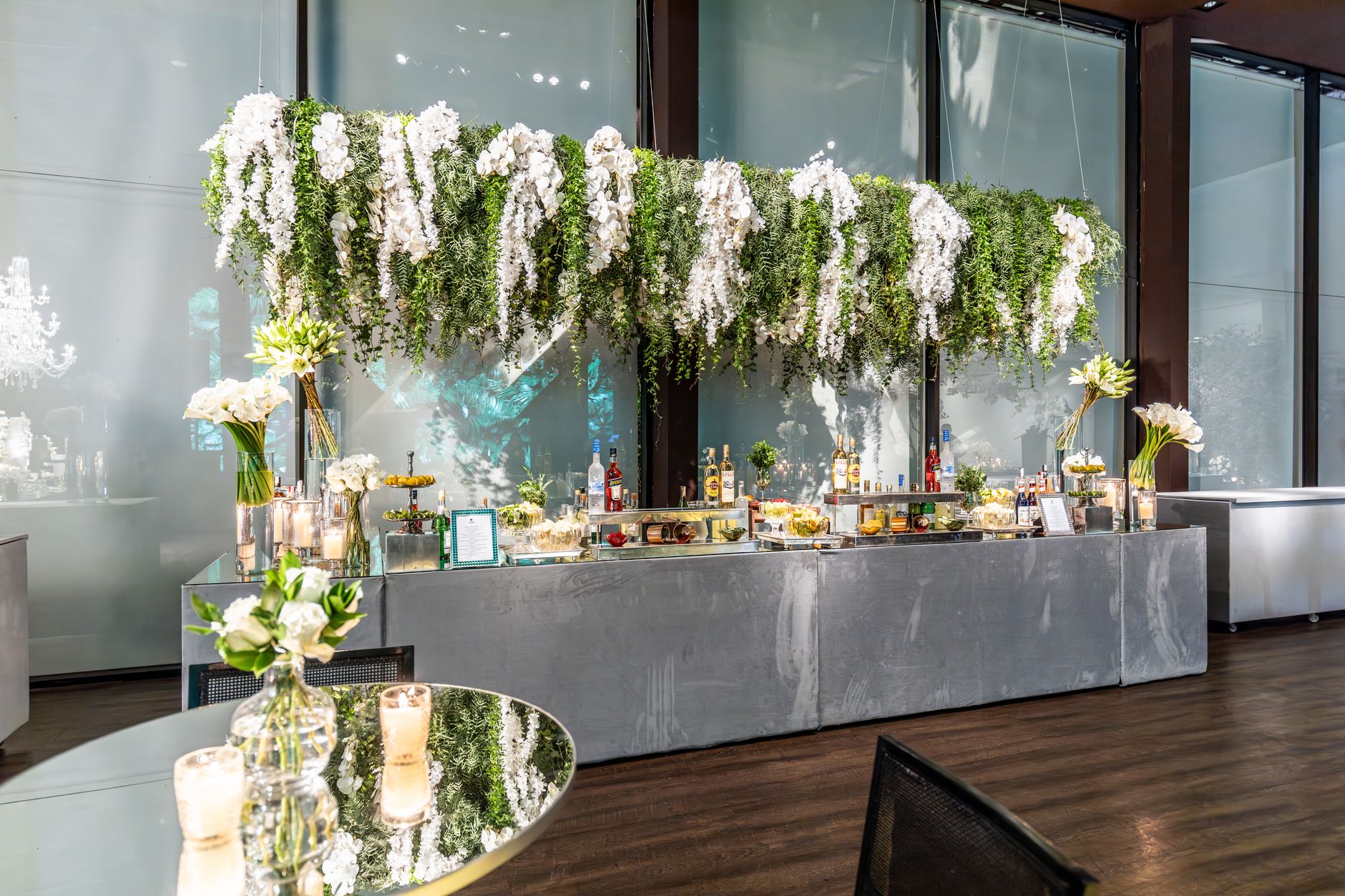 Bright and elegant banquet hall setup with hanging floral decorations for a wedding reception.