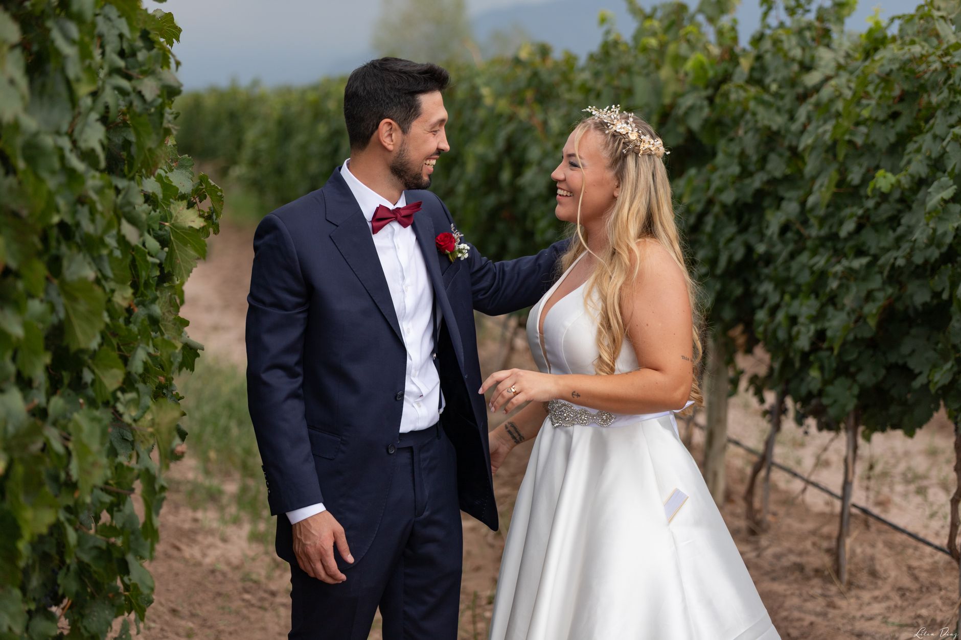 A couple enjoys a romantic vineyard wedding in Mendoza, dressed in elegant attire.