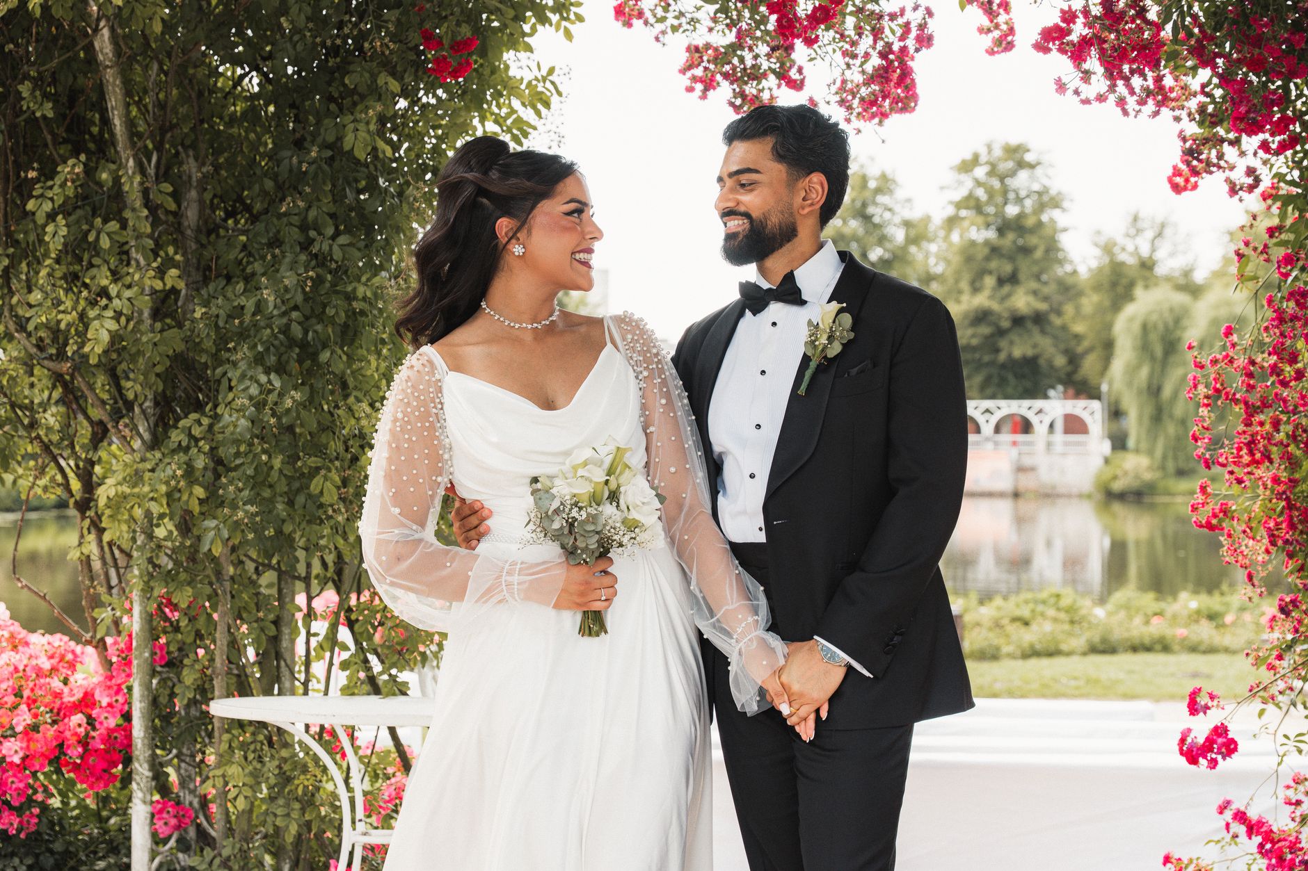 Smiling couple at an outdoor wedding ceremony in Hamburg, surrounded by vibrant flowers.