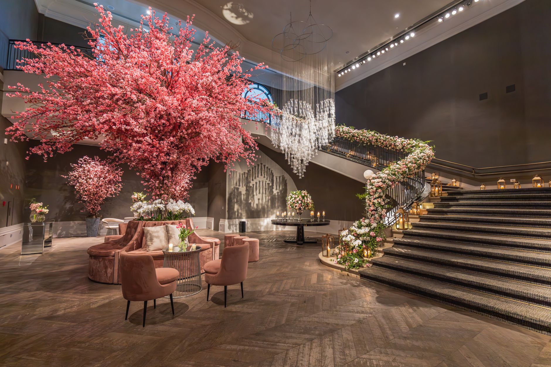 Luxurious hotel lobby with grand floral arrangements and elegant staircase.