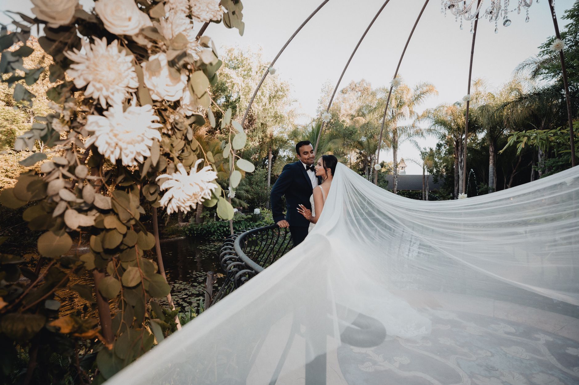 A romantic wedding scene with a bride and groom under a garden canopy in Los Angeles.