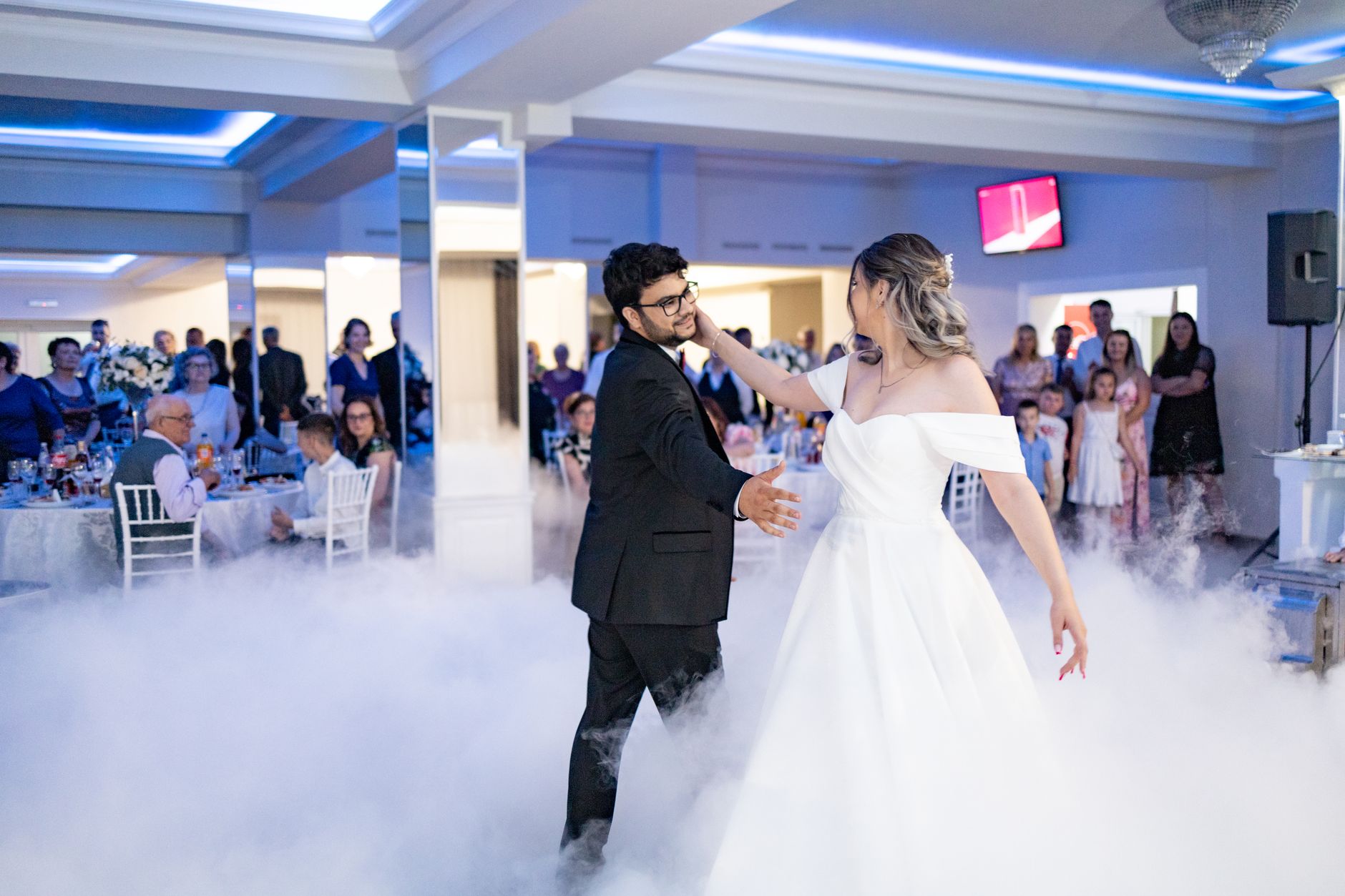 Bride and groom share a romantic first dance at a stylish indoor wedding reception.