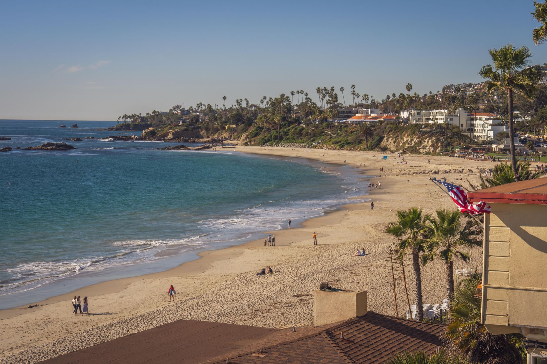 Beautiful sunny day at Laguna Beach with palm trees and shoreline views.