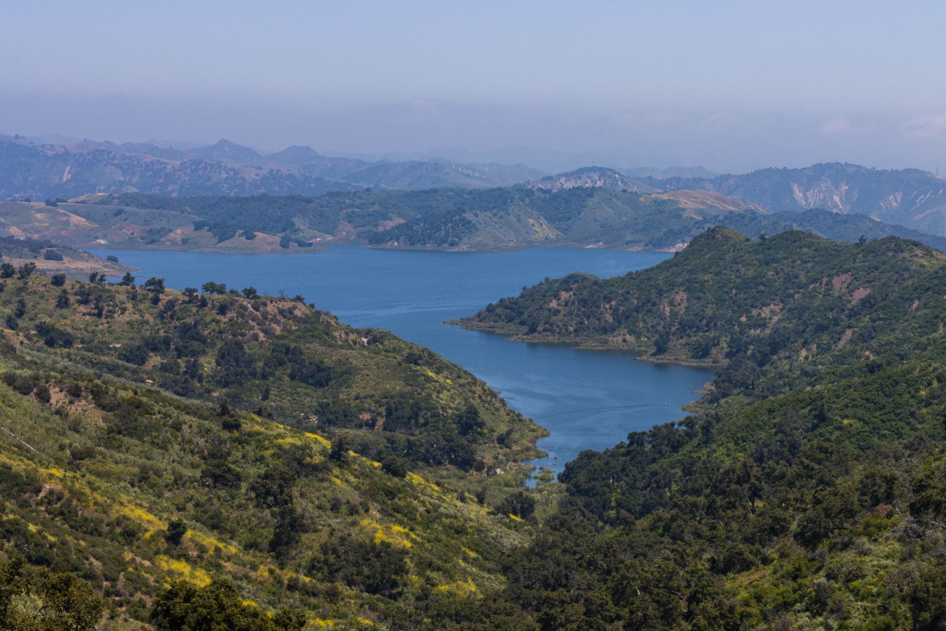 Breathtaking landscape of rolling hills and a serene lake in Ojai, California.