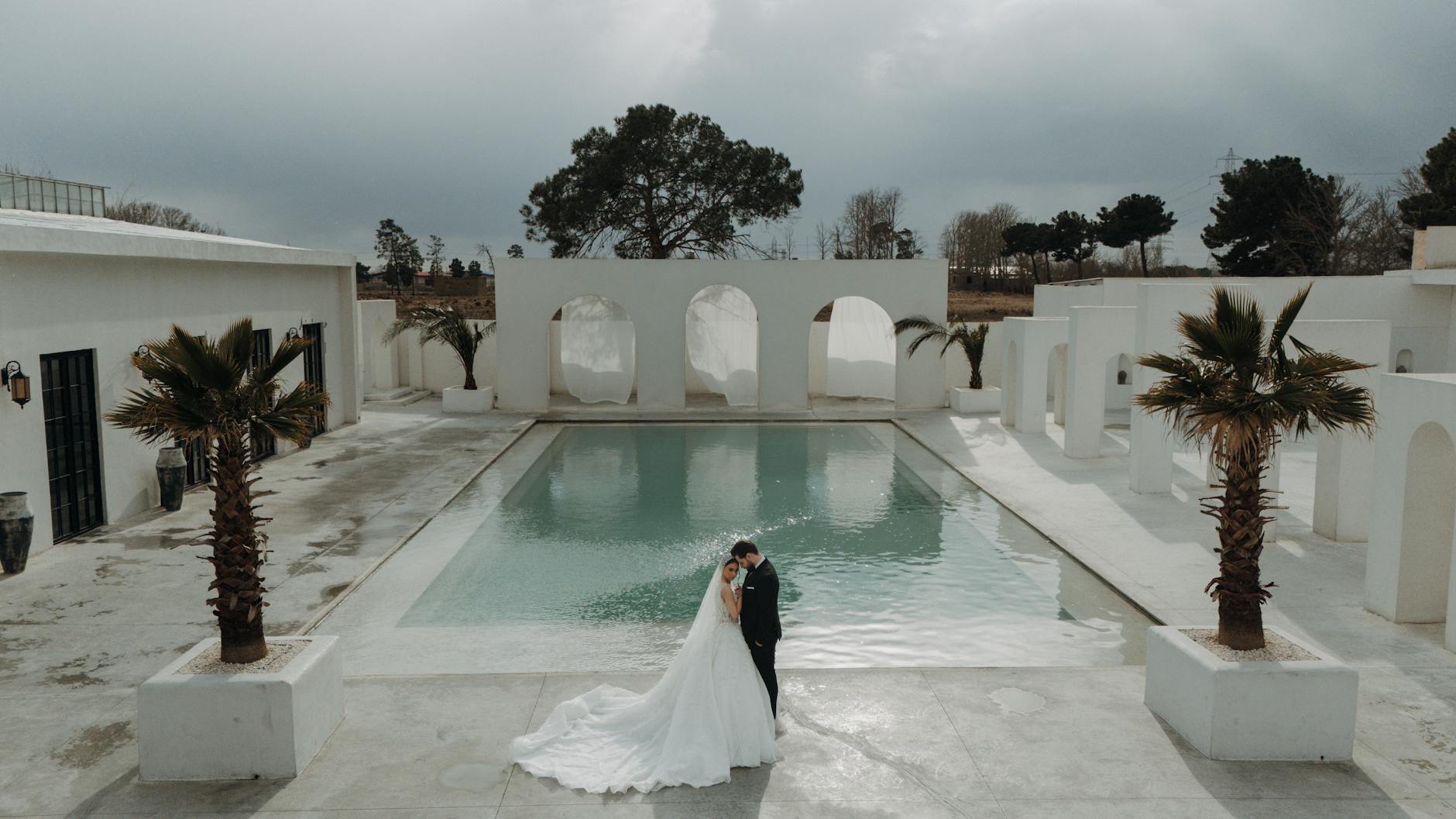 A stunning outdoor wedding with a couple by the pool in Tehran, Iran. Perfect for summer wedding themes.