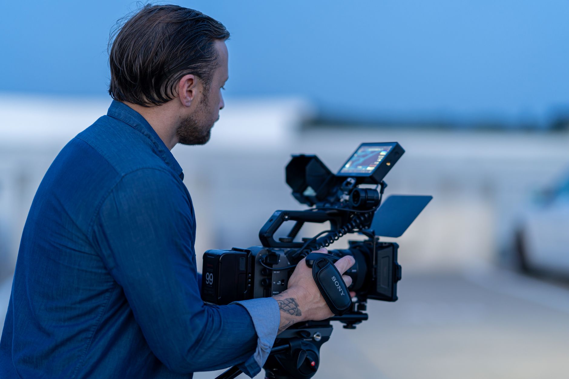 Cinematographer operating a camera during blue hour in Chicago, capturing scenic moments.