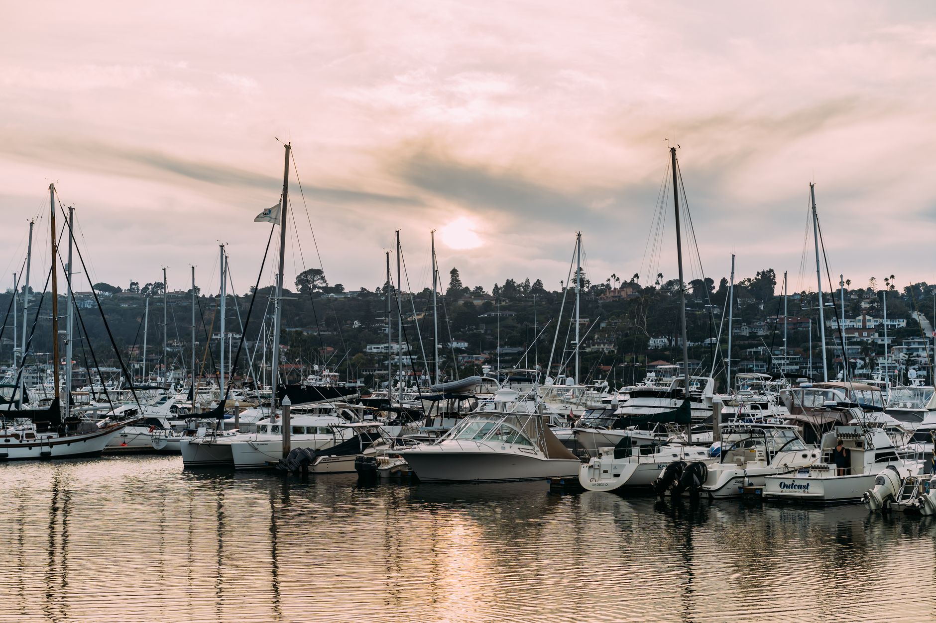A picturesque marina filled with sailboats at sunset, showcasing serene waters and a calming atmosphere.