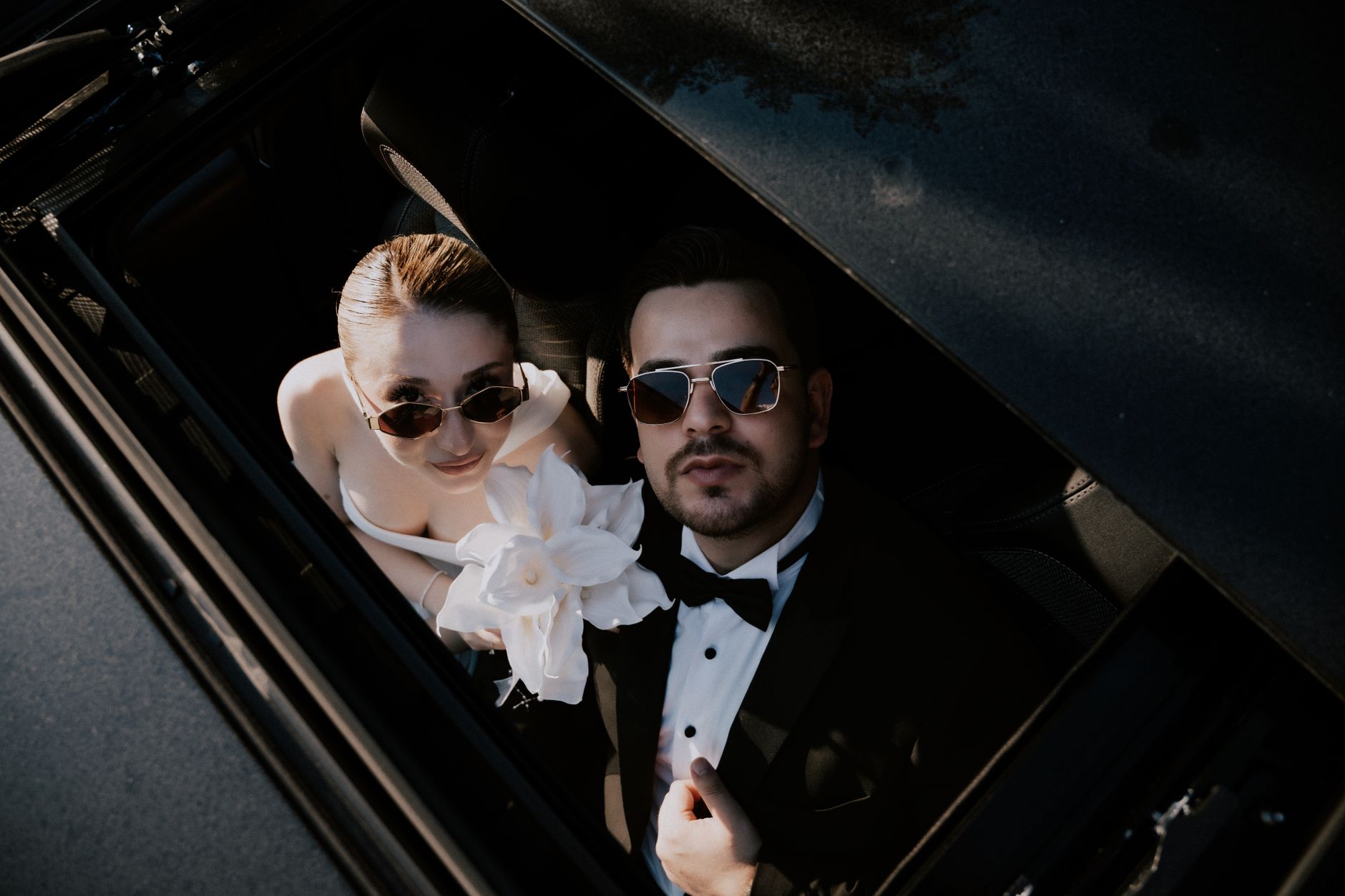 Stylish couple in formal attire spotted from above, embracing love and elegance in Çanakkale, Türkiye.