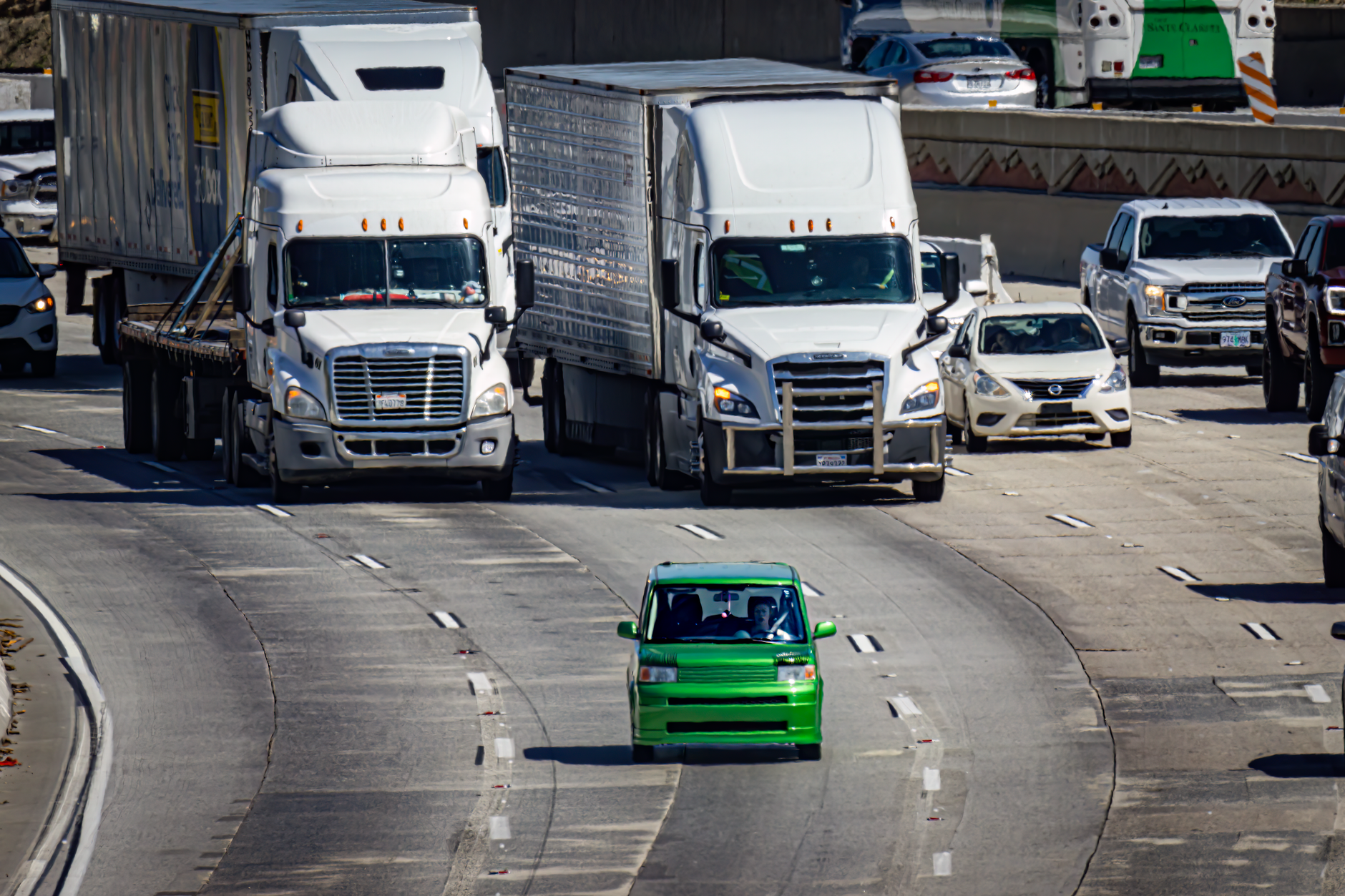Aerial view of a bustling highway with cars and trucks in urban traffic.