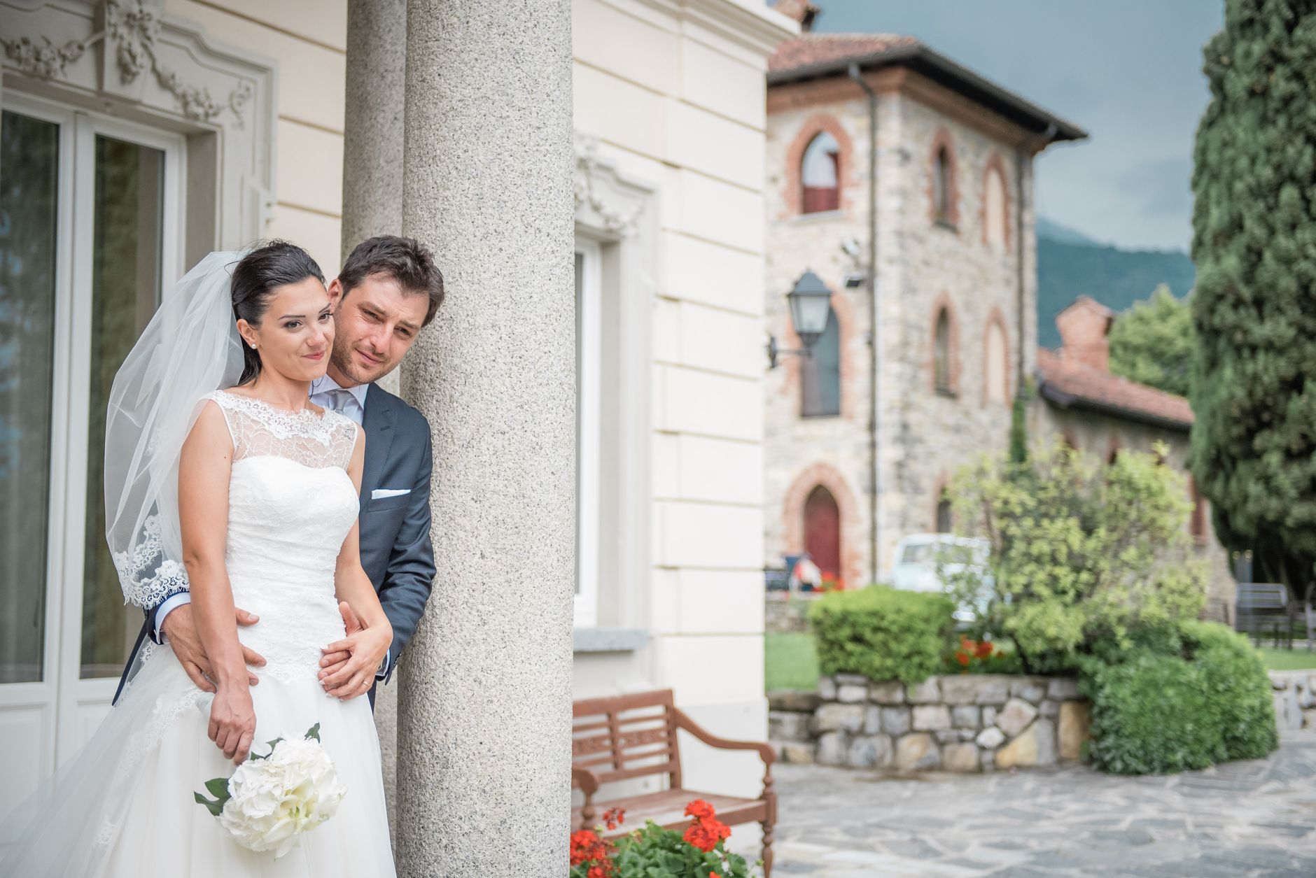 Bride and groom embrace in front of historic building, perfect for wedding inspiration.