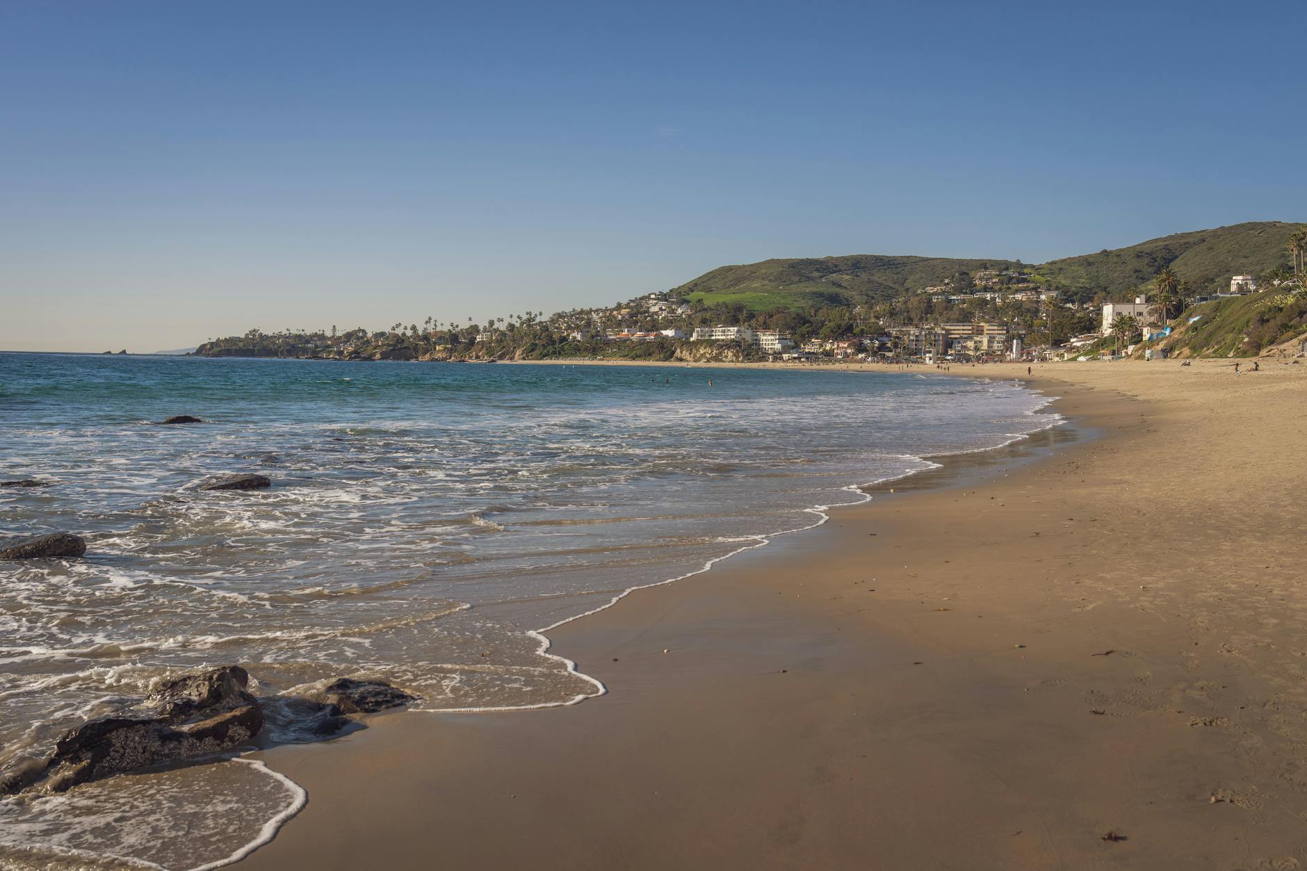 A picturesque view of Laguna Beach with clear skies and gentle waves.